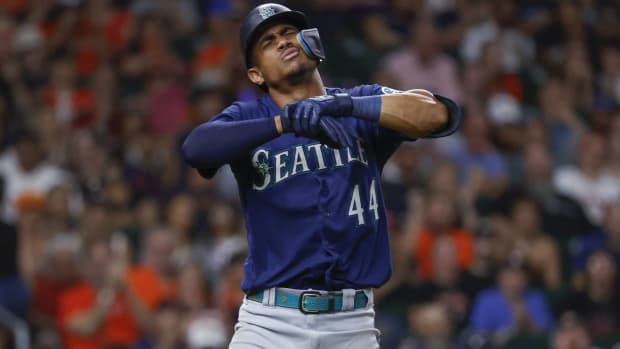 Mariners outfielder Julio Rodríguez holds his right hand after getting hit by a pitch vs. Houston.